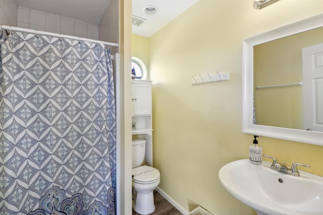 bathroom with tile walls, sink, a shower with shower curtain, and toilet