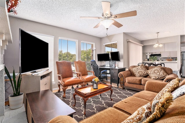 living room with a textured ceiling and ceiling fan