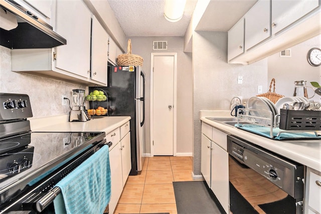 kitchen featuring sink, black appliances, light tile patterned flooring, white cabinetry, and a textured ceiling