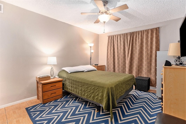 tiled bedroom featuring a textured ceiling and ceiling fan