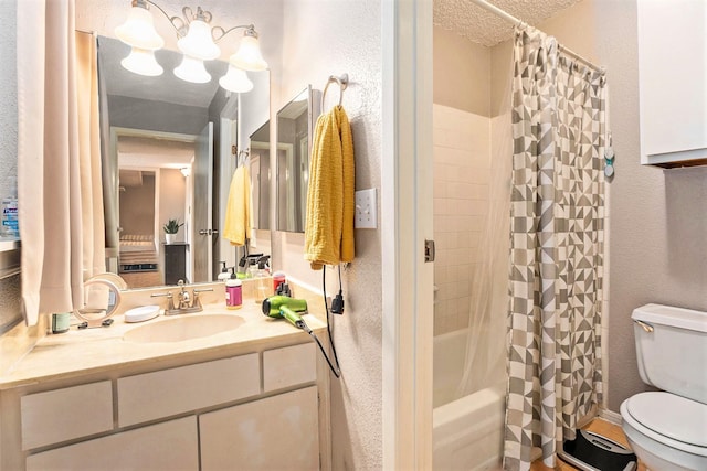 full bathroom with vanity, toilet, a textured ceiling, and shower / bath combo