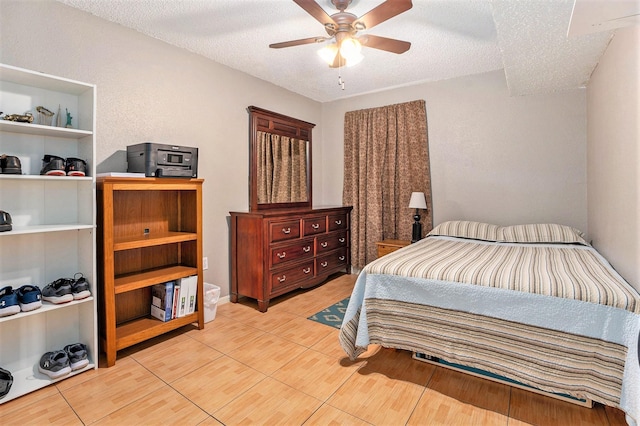 tiled bedroom with ceiling fan and a textured ceiling