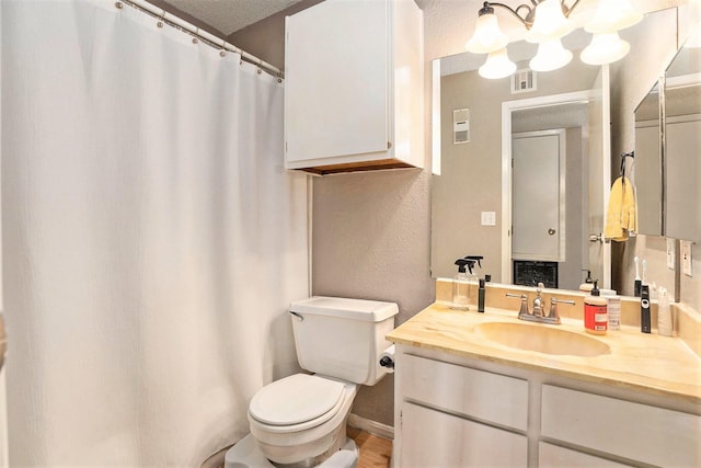 bathroom featuring toilet, a textured ceiling, vanity, and wood-type flooring