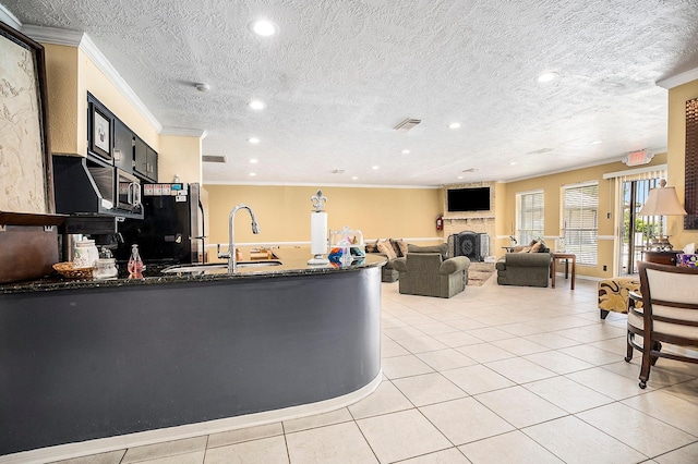 kitchen with ornamental molding, a textured ceiling, sink, and light tile patterned floors