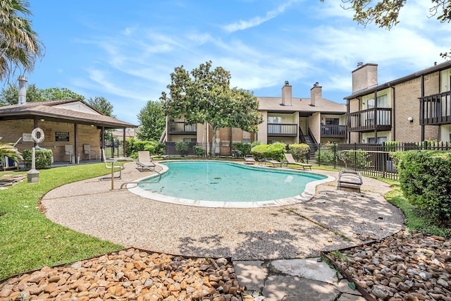 view of pool featuring a patio and a lawn