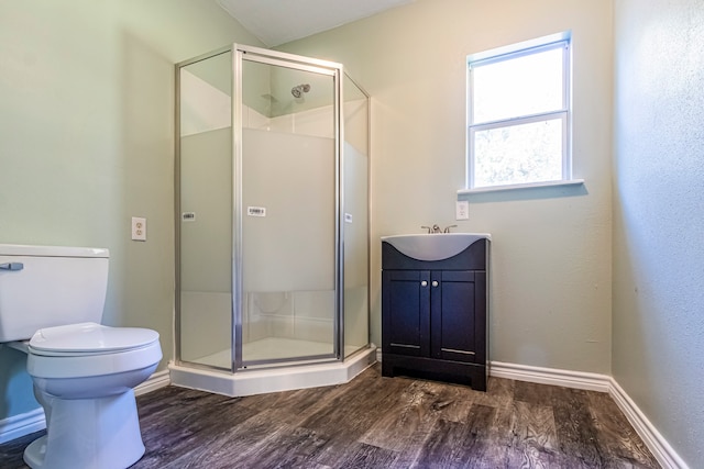 bathroom featuring vanity, toilet, hardwood / wood-style flooring, and a shower with shower door