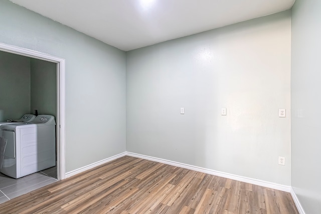 empty room with light hardwood / wood-style flooring and washing machine and dryer