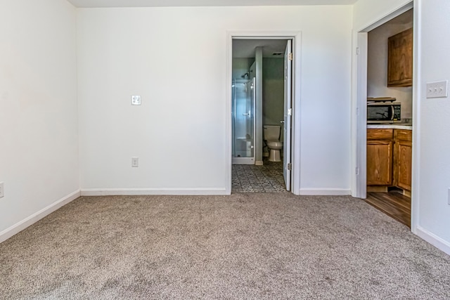 unfurnished bedroom with connected bathroom and light colored carpet