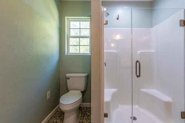 bathroom featuring toilet, tile patterned floors, and an enclosed shower