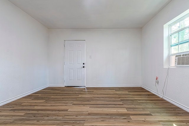 empty room featuring cooling unit and hardwood / wood-style floors