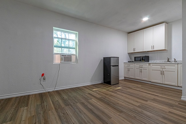 kitchen with cooling unit, white cabinetry, stainless steel refrigerator, dark wood-type flooring, and sink