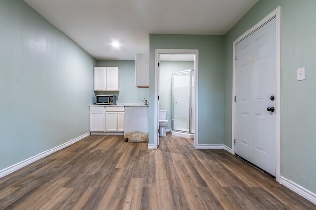 interior space featuring dark wood-type flooring, sink, and white cabinets