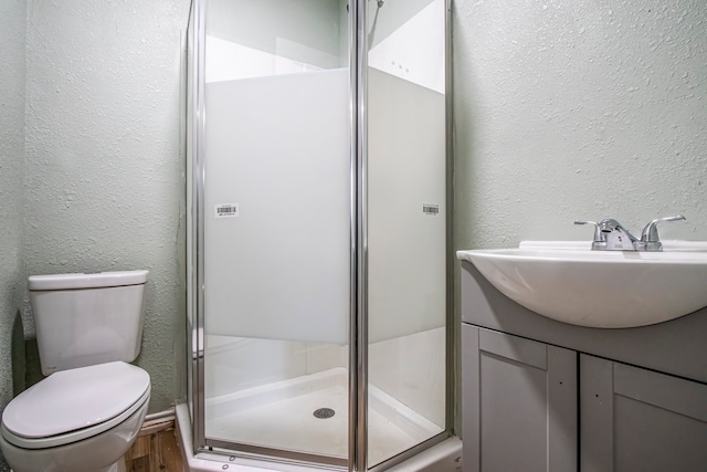 bathroom featuring vanity, wood-type flooring, toilet, and walk in shower