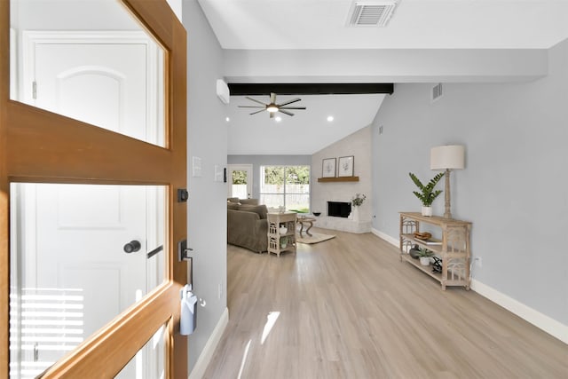 interior space featuring lofted ceiling with beams, light hardwood / wood-style flooring, a large fireplace, and ceiling fan