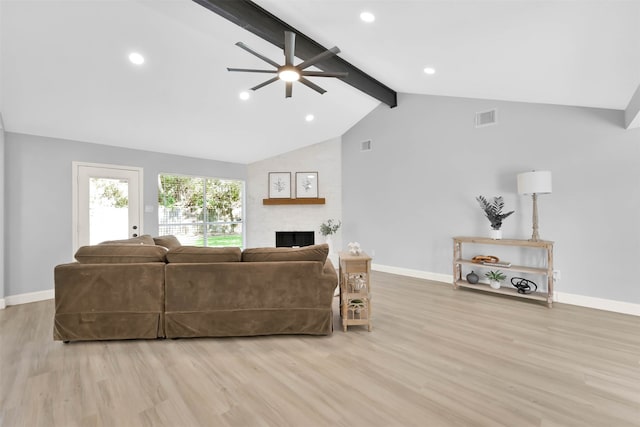 living room featuring light hardwood / wood-style floors, beamed ceiling, a fireplace, and ceiling fan