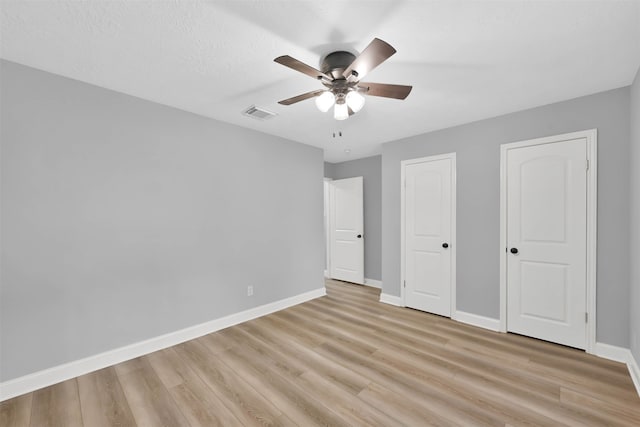 unfurnished bedroom featuring a textured ceiling, light wood-type flooring, and ceiling fan