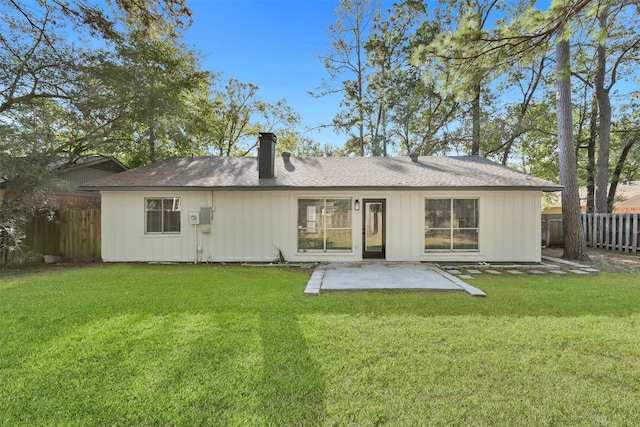 rear view of property with a patio and a lawn