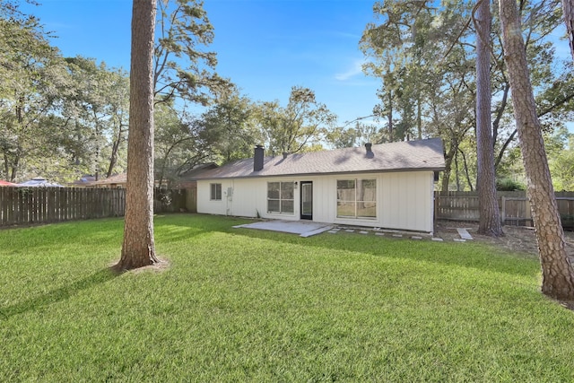 rear view of house with a patio and a lawn