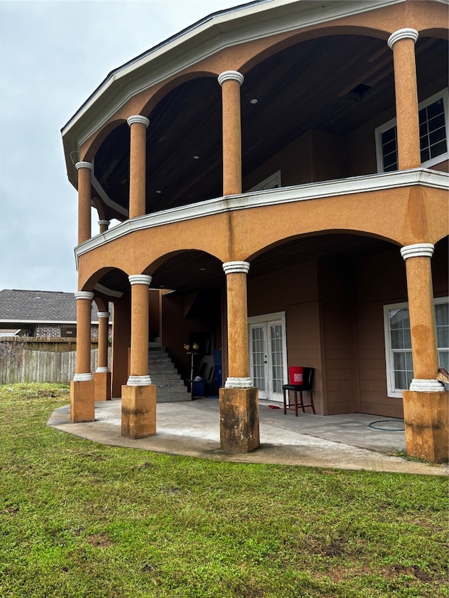 back of property featuring a patio, ceiling fan, a lawn, and french doors