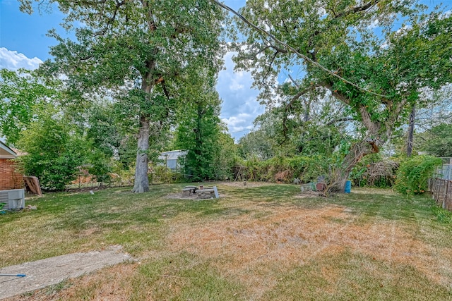 view of yard featuring an outdoor fire pit and central AC unit