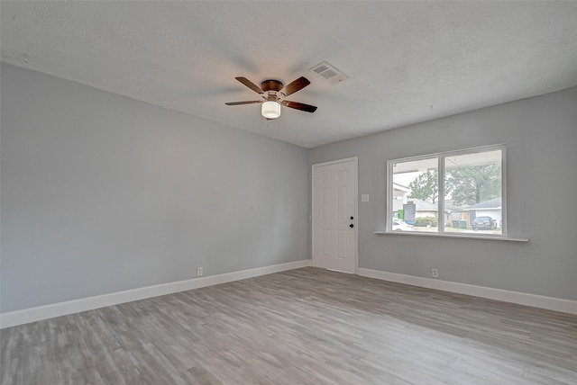 unfurnished room with light hardwood / wood-style flooring, a textured ceiling, and ceiling fan