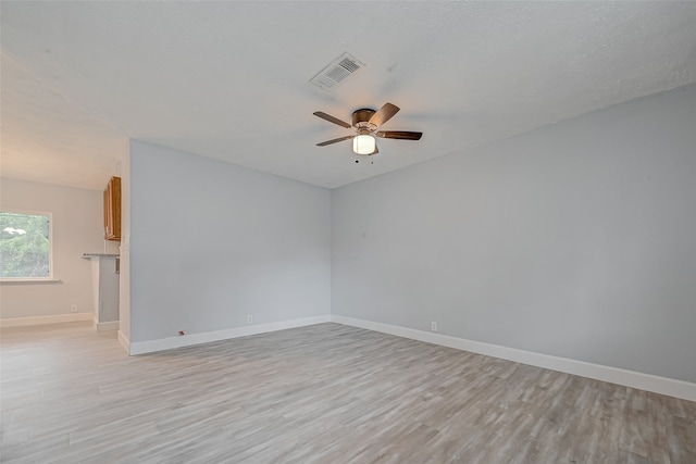 spare room with ceiling fan, a textured ceiling, and light hardwood / wood-style flooring