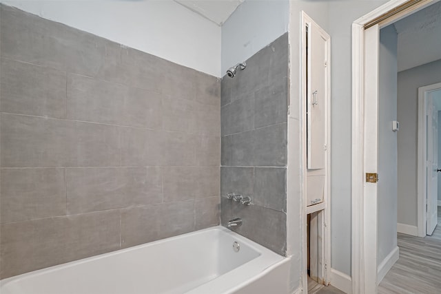 bathroom with tiled shower / bath combo and wood-type flooring