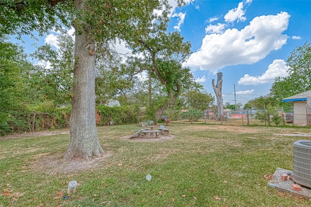 view of yard featuring cooling unit and a fire pit