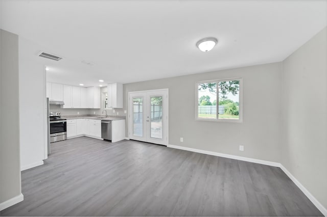 kitchen featuring french doors, appliances with stainless steel finishes, light hardwood / wood-style flooring, and white cabinets