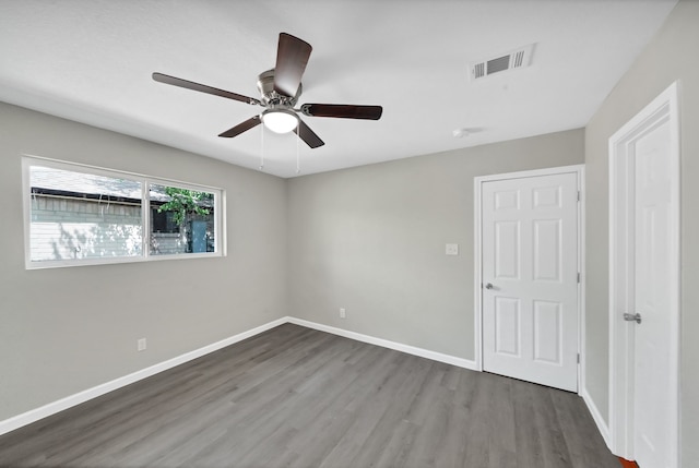 unfurnished room with ceiling fan and dark hardwood / wood-style flooring