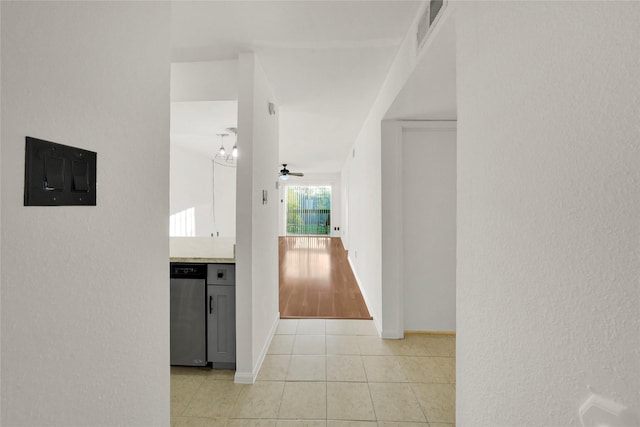 hall with electric panel, baseboards, visible vents, and light tile patterned floors