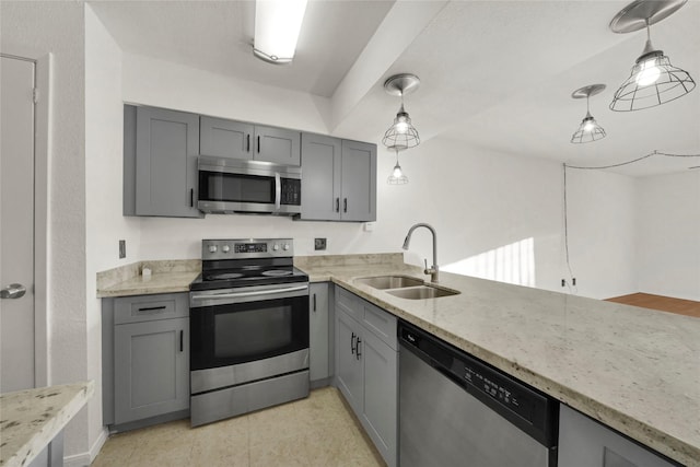 kitchen with a sink, decorative light fixtures, light stone countertops, gray cabinetry, and appliances with stainless steel finishes