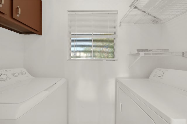 laundry room featuring separate washer and dryer and cabinets