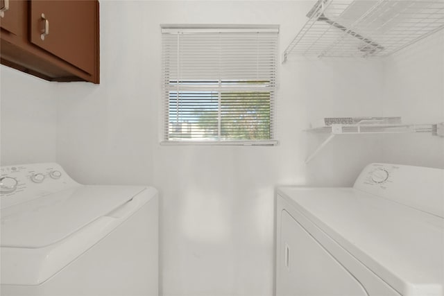 clothes washing area featuring cabinet space and independent washer and dryer