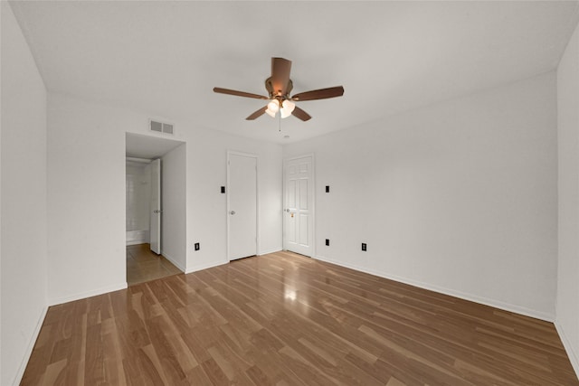 unfurnished bedroom with baseboards, wood finished floors, and visible vents