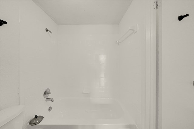 bathroom with toilet and tiled shower / bath