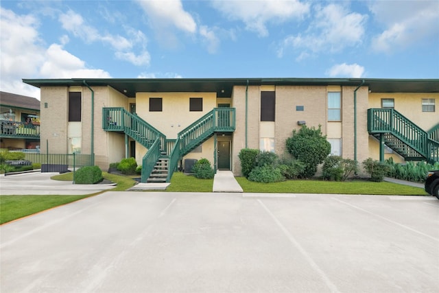 view of property with central air condition unit and stairway