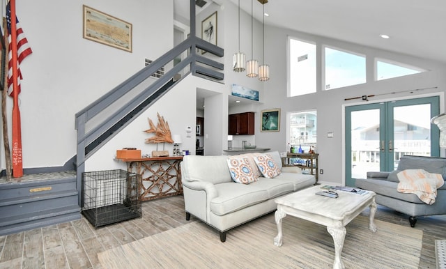 living room featuring french doors, high vaulted ceiling, and light hardwood / wood-style floors