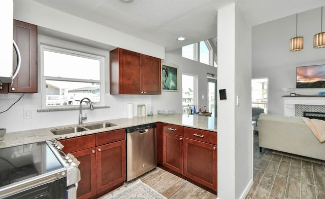 kitchen featuring hardwood / wood-style floors, a healthy amount of sunlight, stainless steel appliances, and light stone counters