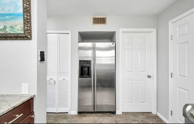 kitchen featuring hardwood / wood-style flooring and stainless steel fridge with ice dispenser