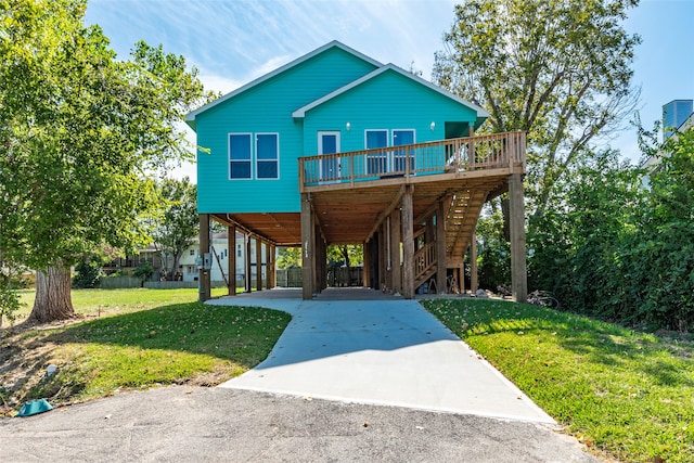 view of front facade with a carport, a deck, and a front lawn