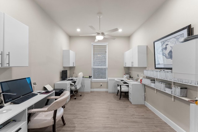 office with light wood-type flooring and ceiling fan