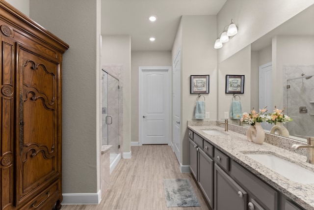 bathroom featuring wood-type flooring, vanity, and a shower with door