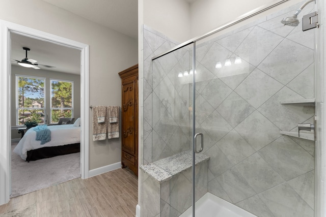 bathroom featuring hardwood / wood-style flooring, ceiling fan, and a shower with shower door