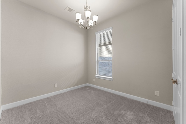 carpeted spare room with a notable chandelier