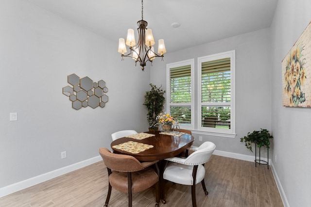 dining space with a notable chandelier and light hardwood / wood-style floors