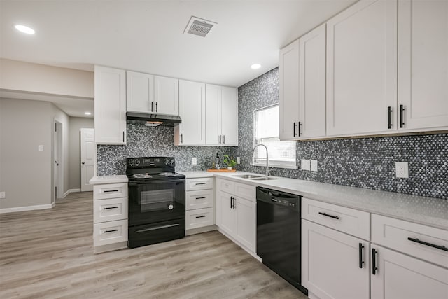 kitchen featuring black appliances, white cabinets, sink, light hardwood / wood-style flooring, and decorative backsplash