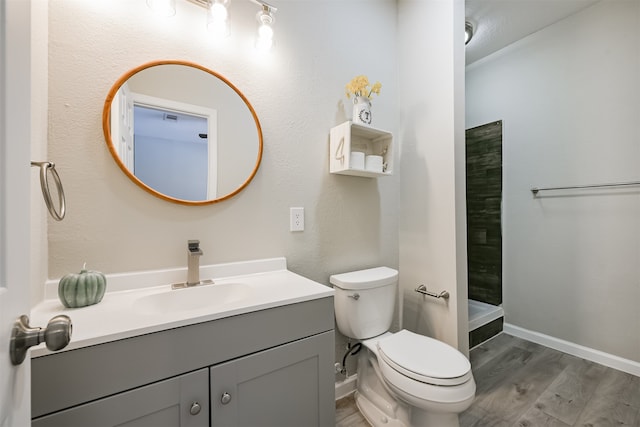 bathroom featuring a shower, vanity, wood-type flooring, and toilet