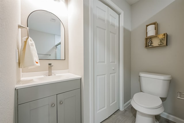 bathroom with hardwood / wood-style floors, vanity, and toilet