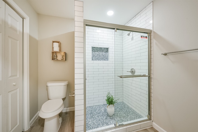 bathroom featuring hardwood / wood-style flooring, toilet, and an enclosed shower